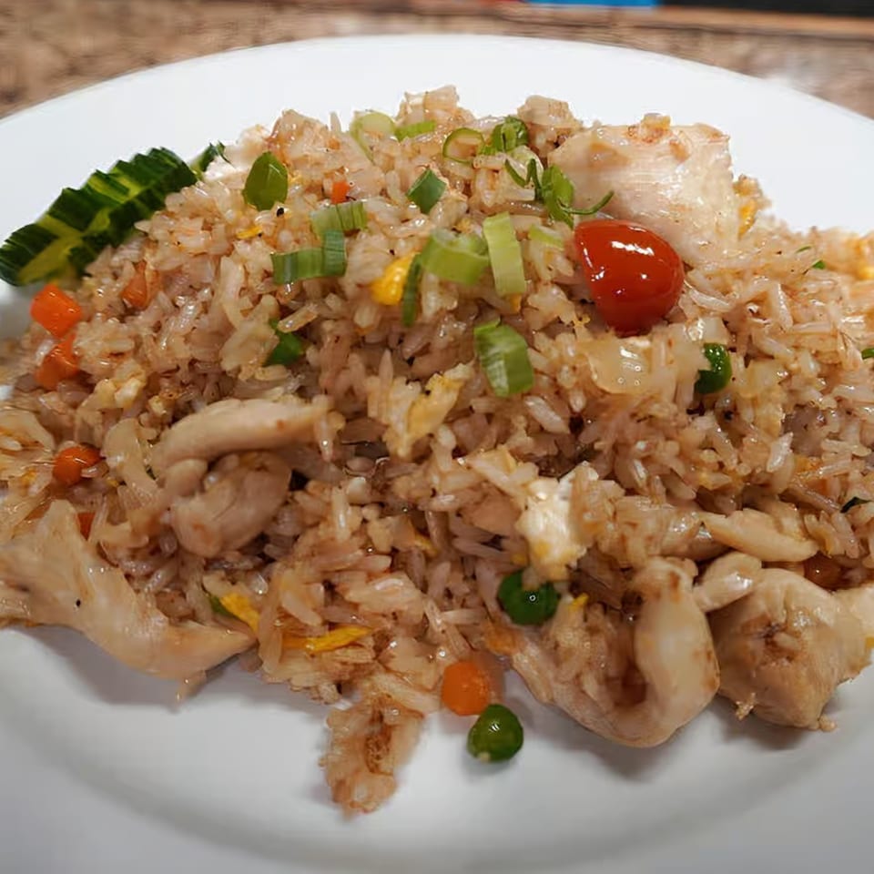 Honey's Bie Thai & Sushi's chicken fried rice with vegetables and a cucumber garnish.